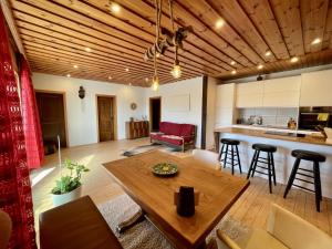 a kitchen and living room with a wooden ceiling at Das Haus am See - der idyllische Privatsee nahe Wien in Tulln