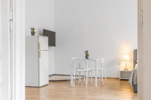 a white kitchen with a table and chairs in a room at Attractive 2 BR Apt. near Vienna AKH Ideal for All in Vienna