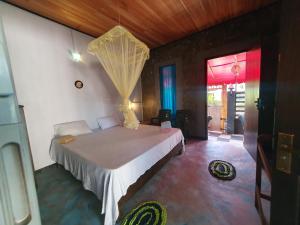 a bedroom with a bed with a mosquito net at Turtle Village Guest Mirissa in Mirissa +63 photos