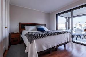 a bedroom with a large bed and a balcony at Estancia única y exclusiva! in Santiago