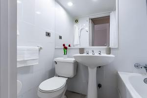 a white bathroom with a toilet and a sink at Estancia única y exclusiva! in Santiago +15 photos