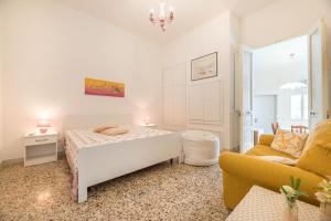 a white bedroom with a bed and a couch at La Dimora Lucia by Paf in tour in Torre Suda