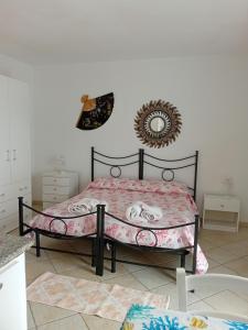 - une chambre avec un lit et une couverture rose dans l'établissement Casa Terme Romane, à Castelsardo