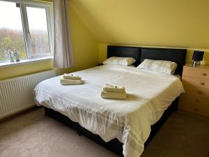 a bedroom with a bed with two towels on it at Puffin Place in Flamborough