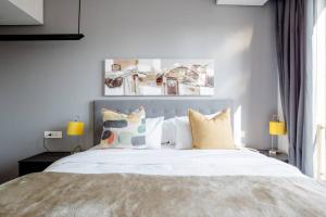 a bedroom with a large white bed with pillows at The Capital On the Park Self-Catering Apartments in Johannesburg