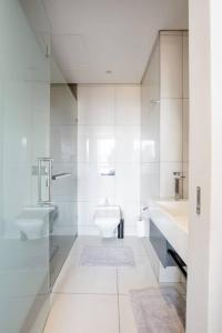 a white bathroom with a sink and a toilet at The Capital On the Park Self-Catering Apartments in Johannesburg