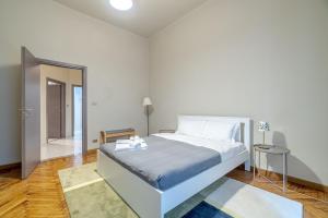 ein weißes Schlafzimmer mit einem Bett und einem Flur in der Unterkunft Inalpi Arena & MM Nizza Subway Flat in Turin