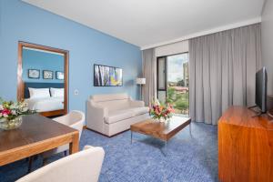 a living room with a couch and a television in a room at Hilton Garden Inn Windhoek in Windhoek