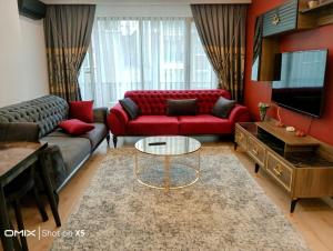 een woonkamer met een rode bank en een tafel bij 2+1 lüks rezidans in Istanbul