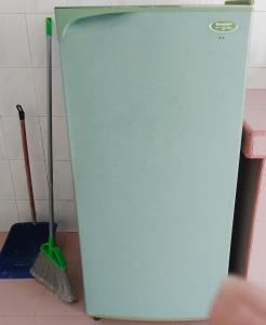 a blue refrigerator in a kitchen with a broom at Pilah homestay in Kuala Pilah