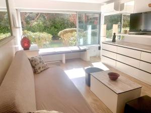 a living room with a couch and a large window at 3 étoiles au bord de l'eau in La Seyne-sur-Mer