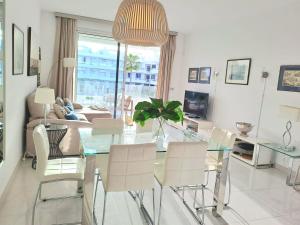a living room with a glass table and chairs at Noctua Estepona Luxury Apartment Belair 005 in Estepona