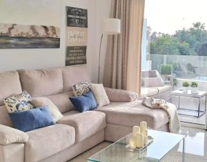 a living room with a couch and a glass table at Noctua Estepona Luxury Apartment Belair 005 in Estepona