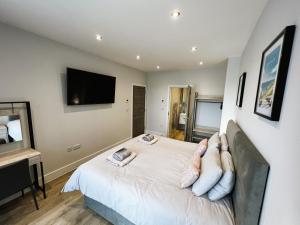 1 dormitorio con 1 cama y TV de pantalla plana en Colonels Apartment - Pet friendly, en Sandown