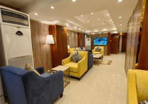 Zad al Bait Hotel في مكة المكرمة: غرفة معيشة مع كراسي زرقاء وكراسي صفراء