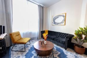 a living room with a black couch and a coffee table at E10-1 Designer East Village Townhouse 1BR in New York