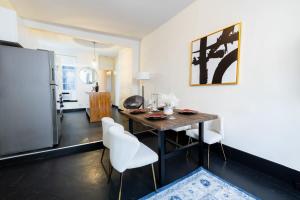 a kitchen and dining room with a table and white chairs at E10-1 Designer East Village Townhouse 1BR in New York