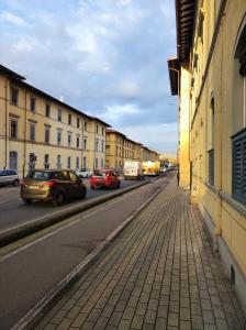 a street with cars driving down a city street at Dimora Pietra Blu in Pisa