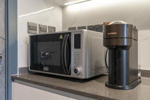 a microwave sitting on a counter next to a coffee maker at TAMM HOMES-SAMANA GOLF AVENUE in Dubai