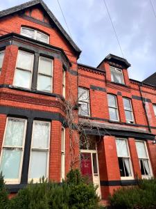 stary dom z czerwonej cegły z czerwonymi drzwiami w obiekcie Ullet Suites w Liverpoolu