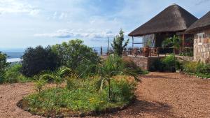 ein Haus mit einem Strohdach und einem Garten in der Unterkunft Akagera Ihema lodges in Rwinkwavu