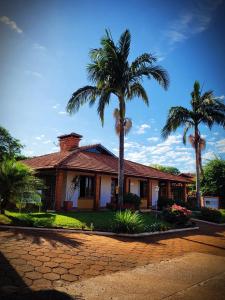 聖米格爾達斯米索伊斯的住宿－Pousada das Missoes，前面有棕榈树的房子