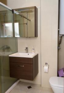 un bagno con lavandino, specchio e WC di Cozy 2BD Flat with Balcony and Workspace by Flat Mаnager a Golden Sands