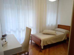 1 dormitorio con 1 cama, 1 mesa y 1 silla en Appartamento Casa Alice, en Omegna