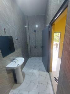 uma casa de banho com um lavatório e um chuveiro em RESIDENCE BELIER KEUR MOUSSA 