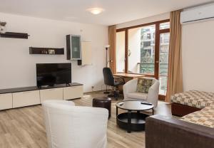 un soggiorno con un divano e una TV di Cozy 2BD Flat with Balcony and Workspace by Flat Mаnager a Golden Sands