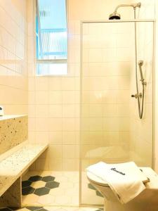 uma casa de banho com um WC e uma cabina de duche em vidro. em Incrível Apartamento na Quadra da Praia no Rio de Janeiro