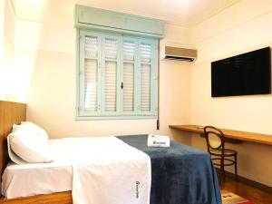um quarto com uma cama, uma secretária e uma janela em Incrível Apartamento na Quadra da Praia no Rio de Janeiro