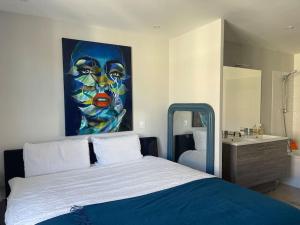 um quarto com uma cama e um quadro na parede em Splendide T3 avec piscine + Terrasse à 7 min d’Aix em Aix-en-Provence