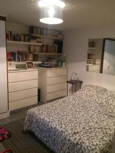 una camera con un letto e alcuni cassetti bianchi di Maison à 2 pas de Paris ! a Bagnolet