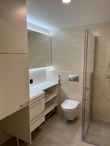 een witte badkamer met een toilet en een douche bij Moderni perhehuoneisto parhaalla sijainnilla in Espoo