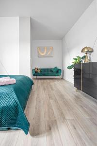 1 dormitorio con cama verde y suelo de madera en Novel NeW, en Varsovia