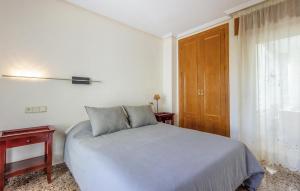 Schlafzimmer mit einem Bett und einer Holztür in der Unterkunft Lovely Apartment In Alacant With Wifi in Alicante