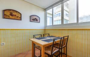 ein Tisch und Stühle in einem Raum mit gelben Streifen in der Unterkunft Lovely Apartment In Alacant With Wifi in Alicante