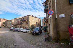 a street with cars parked on the side of a building at La Nicchia in Tirli