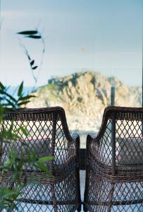 Duas cadeiras de vime sentadas em cima de uma varanda em Hostal Sa Malica em Blanes