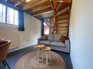 a living room with a couch and two stools at Hotel De Hoogmolen in Oudsbergen 