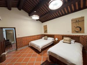 a bedroom with two beds in a room at Ba Ba Guan Hai Ancient House B&B in Jinsha