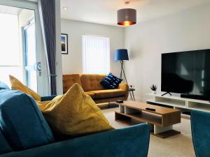 a living room with a couch and a tv at Colonels House in Sandown