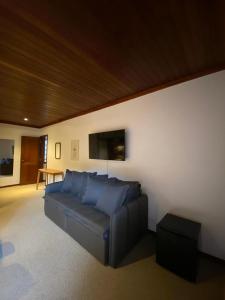 uma sala de estar com um sofá azul num quarto em Tília Pousada de Charme em Campos do Jordão