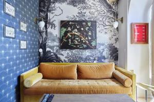 a couch in a living room with a blue wall at 299 Suite Nansouty - Superbe Appartement à Paris in Paris