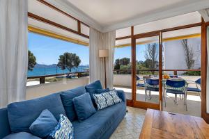 Sofá azul en la sala de estar con vistas al océano en Llenaire 1, sea view, pool, wifi, en Puerto Pollensa