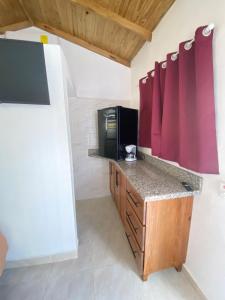 a kitchen with a counter with a microwave and a television at Villa Bellevue in San Felipe de Puerto Plata