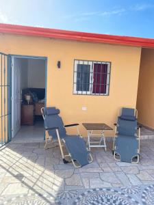 a patio with chairs and a table in front of a house at Villa Bellevue in San Felipe de Puerto Plata