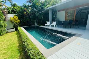 a swimming pool in a yard next to a house at Private Garden Villa in Las Terrenas