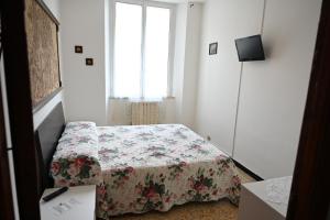 um pequeno quarto com uma cama com colcha floral em Il Capriolo em Tavernelle